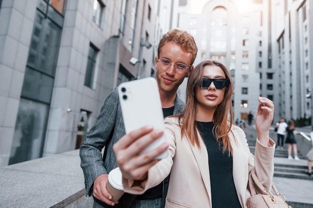 Robi selfie Kobieta i mężczyzna w mieście w dzień Dobrze ubrani ludzie