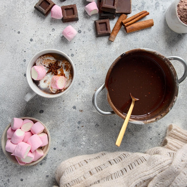 Robienie gorącej czekolady . Metaliczne laski cynamonu w kawałkach czekolady w proszku kakao i prawoślazu