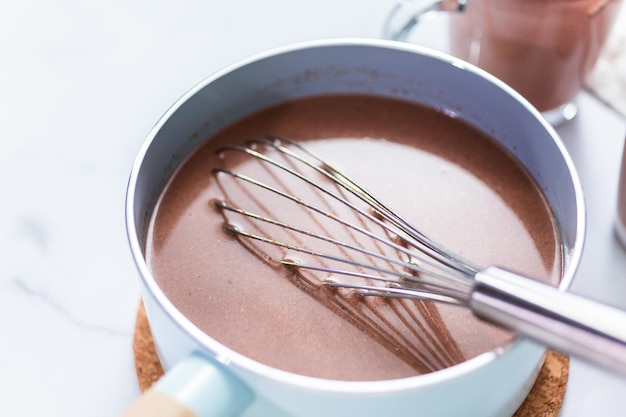 Robienie gorącej czekolady po amrican w małym garnku.