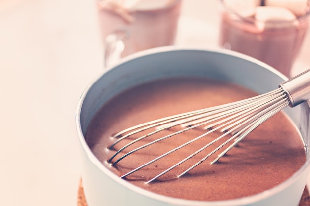 Robienie gorącej czekolady po amrican w małym garnku.