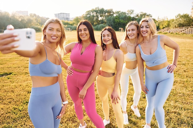 Robienie selfie Grupa kobiet ma razem fitness na świeżym powietrzu na boisku