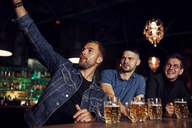 Robienie Selfie. Trzech Fanów Sportu W Barze Ogląda Piłkę Nożną. Z Piwem W Rękach.