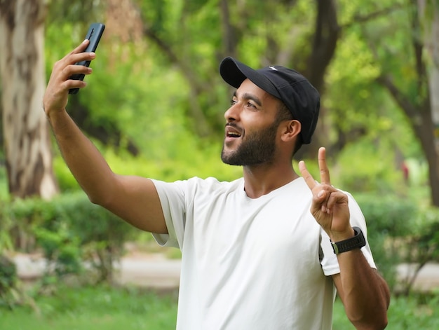 Robienie Selfie Za Pomocą Telefonu Komórkowego I Pokazywanie Znaku Zwycięstwa