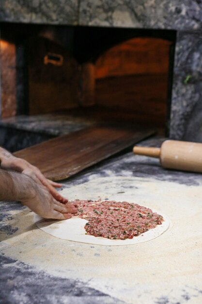 Robienie tureckiej pizzy lub fast foodów lahmacun i popularnego street foodu w krajach śródziemnomorskich