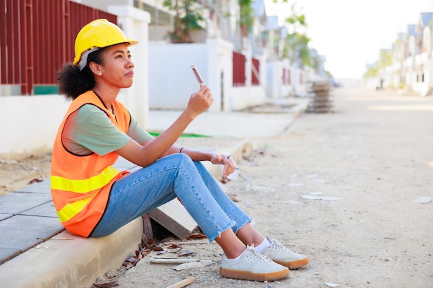 Robotnicy budowlani odpoczywają i jedzą śmietanę w projektach mieszkaniowych Profesjonalne czarnoskóre inżynierki pochodzenia afroamerykańskiego