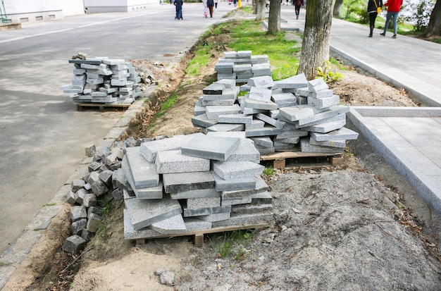 Roboty drogowe na starym mieście. Kamienne bloki i płytki chodnikowe na ziemi. Przebudowa na ulicach. Naprawa chodnika.