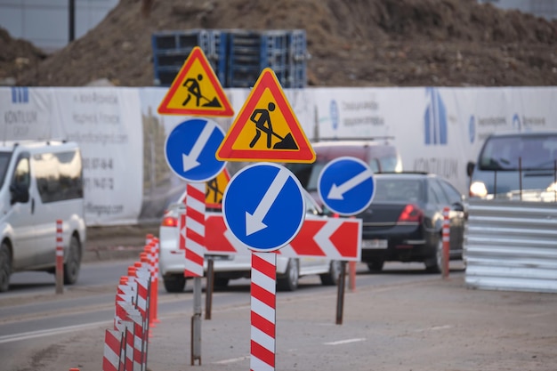 Roboty drogowe ostrzegające znaki drogowe o pracach budowlanych na ulicy miejskiej i wolno poruszające się samochody