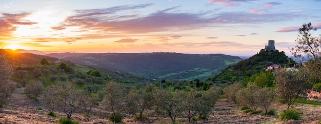 Rocca d'Orcia, średniowieczna wioska i twierdza w Toskanii we Włoszech. Niepowtarzalny widok o zmierzchu, kamienna wieża wznosząca się na skalnym klifie na tle dramatycznego nieba.