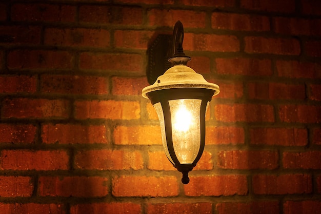 Rocznik lampa blisko starej krakingowej cegły ściany