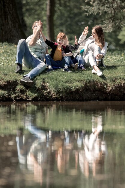 Rodzice i dzieci przybijają sobie piątkę na spacerze w koncepcji rodziny Parkhappy