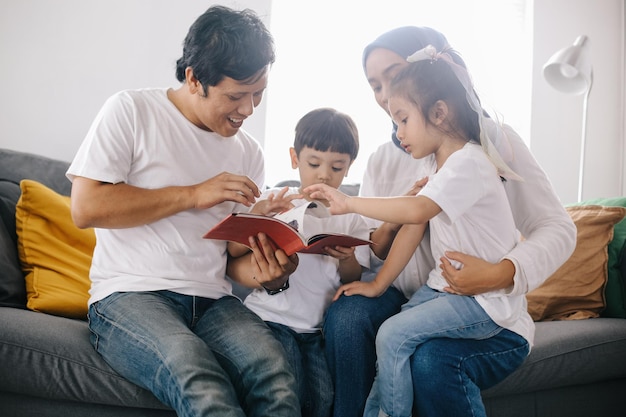 Zdjęcie rodzice uczą dzieci ojciec czyta w domu córce i synowi opowieść z książek