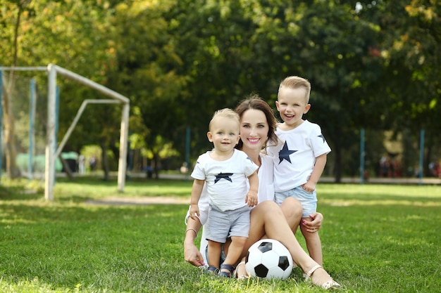 Zdjęcie rodzina bawiąca się piłką w letnim parku