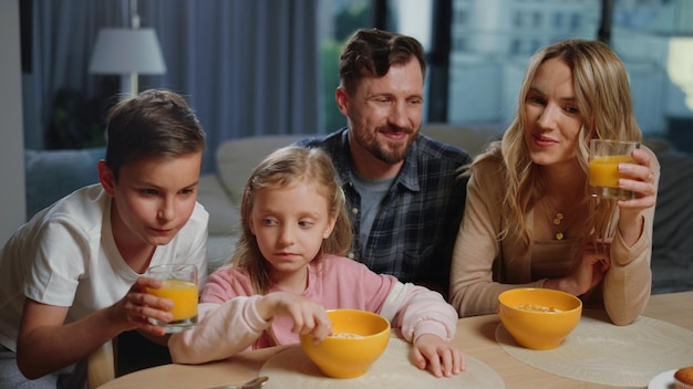 Rodzina jedząca śniadanie przed laptopem Mili ludzie robią wideorozmowy do domu?