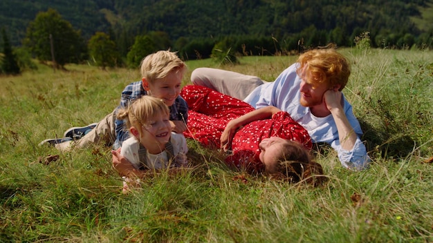 Zdjęcie rodzina leżąca na polu z dziećmi