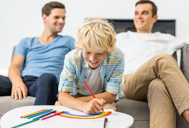 Rodzina LGBT, para gejów z adoptowanym synem - homoseksualni rodzice z dzieckiem bawią się w domu