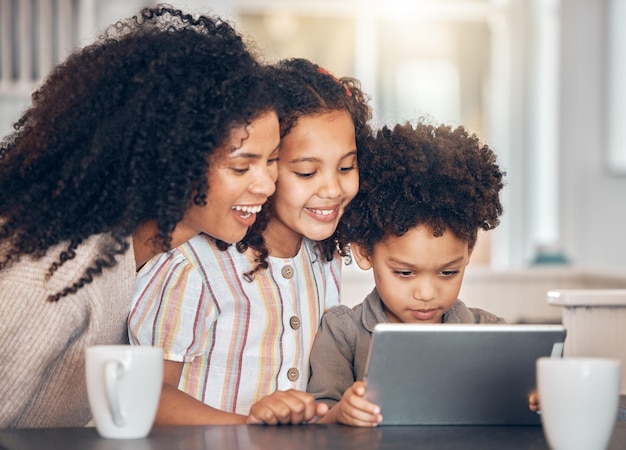 Rodzina matka i dzieci na tablecie do domowej e-uczenia się edukacji online i oglądania lub przesyłania strumieniowego kreskówek Szczęśliwe afrykańskie dzieci i mama korzystające z technologii cyfrowej do wsparcia nauczania i strony internetowej szkoły