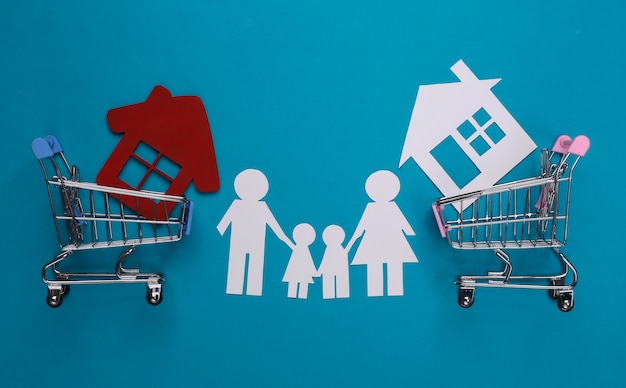 Rodzina papieru razem i wózki na zakupy z domem na niebiesko. Koncepcja zakupu domu