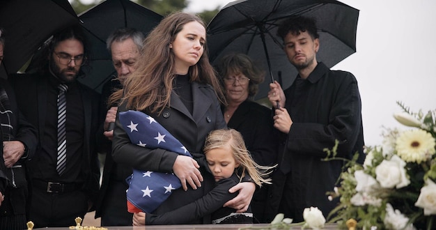 Rodzina pogrzebowa i smutni ludzie z amerykańską flagą smutek i żałoba pogrzeb śmierci i wdowa przygnębiona na pożegnaniu matka dziecka i grupa gromadzą się przy trumnie i płaczą na ceremonii