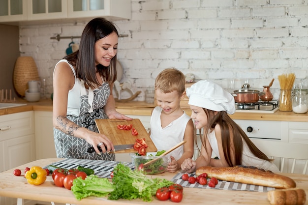 Rodzina Przygotowuje Obiad W Kuchni. Mama Uczy Córkę I Syna Przygotowania Sałatki Ze świeżych Warzyw. Zdrowa Naturalna żywność, Witaminy Dla Dzieci