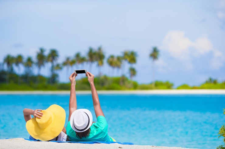 Zdjęcie rodzina składająca się z dwóch osób robi selfie z telefonem komórkowym na plaży