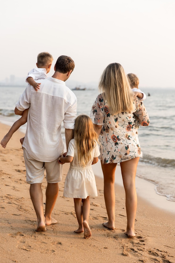 Zdjęcie rodzina spacerująca po plaży z oceanem w tle