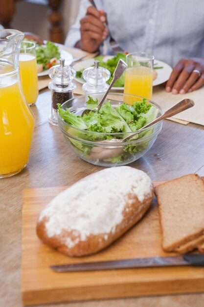 Rodzina spożywająca lunch razem chleba i sałatki