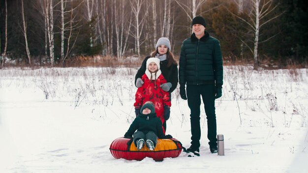Rodzina stojąca na zewnątrz w zimie i patrząca w kamerę