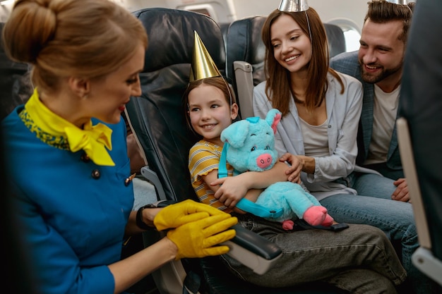 Rodzina świętująca urodziny dziecka i rozmawiająca ze stewardesą w samolocie