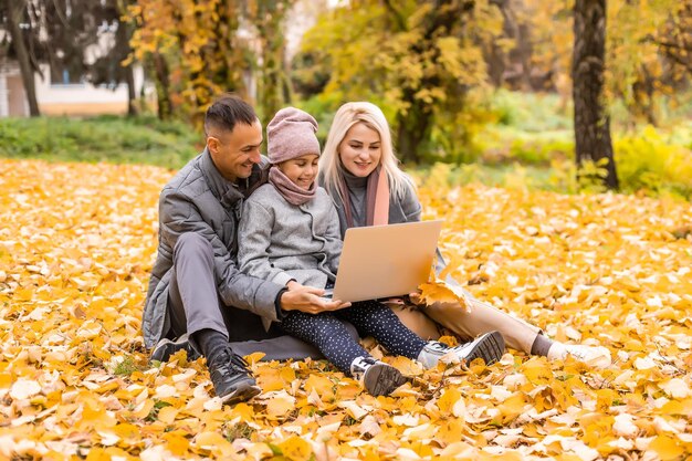 Rodzina z laptopem w jesienny dzień