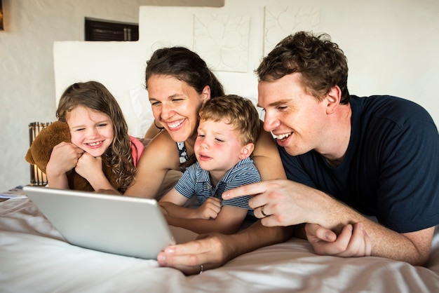 Rodzina za pomocą laptopa w łóżku