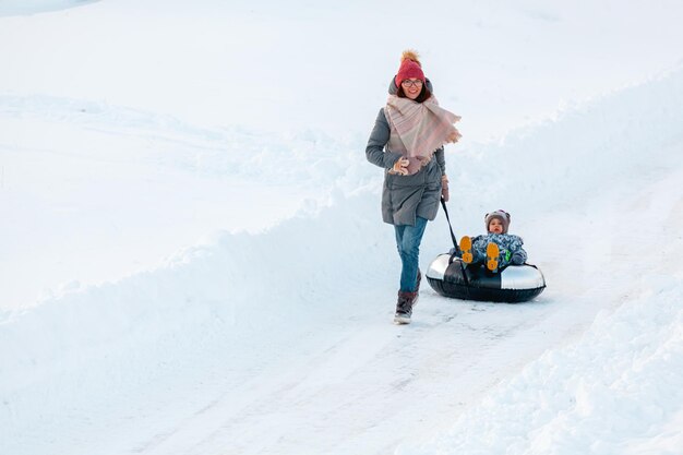 Rodzinna mama i dziecko zima razem na snowtubing na