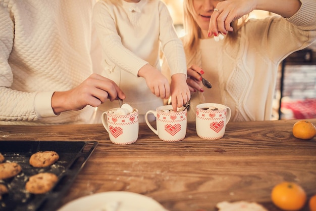 Rodzinna Mama, Tata I Córka Gotują I Piją Kakao Z Piankami. Zbliżenie Dłoni I Kubków