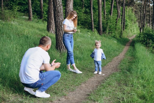 Rodzinna sesja zdjęciowa na ulicy w ciepły słoneczny dzień w lesie iglastym wiosną