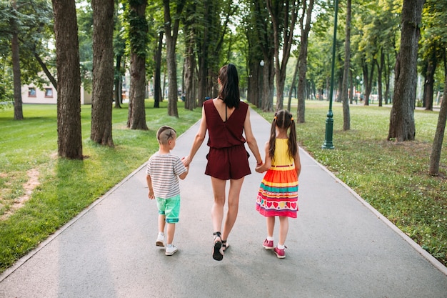 rodzinna wycieczka do parku przyrodniczego. mama spaceruje z dwójką dzieci