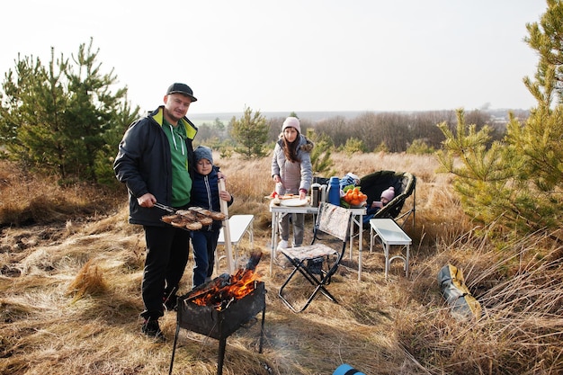 Rodzinne grillowanie na tarasie w sosnowym lesie. Dzień grillowania z grillem.