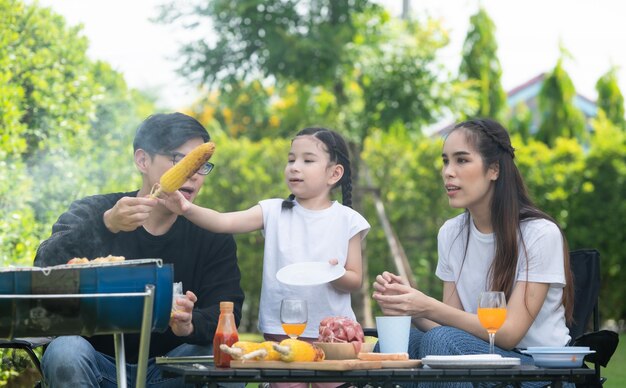 Rodzinne zajęcia wakacyjne obejmują ojca matkę i dzieci z grillem kempingowym i wspólną zabawę na podwórku na wakacjach