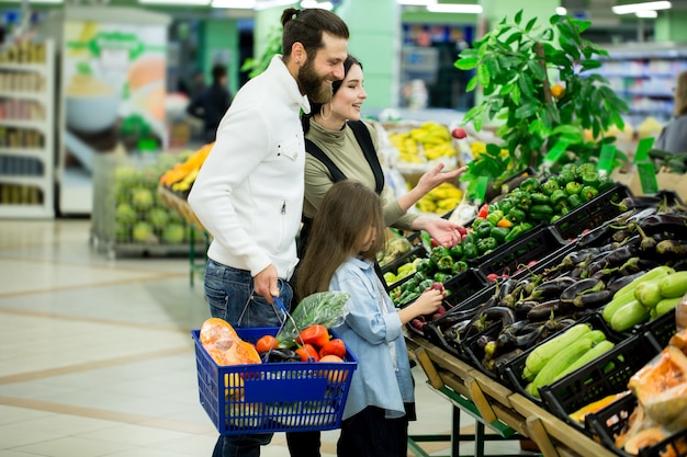 Rodzinni kupień warzywa przy supermarketem