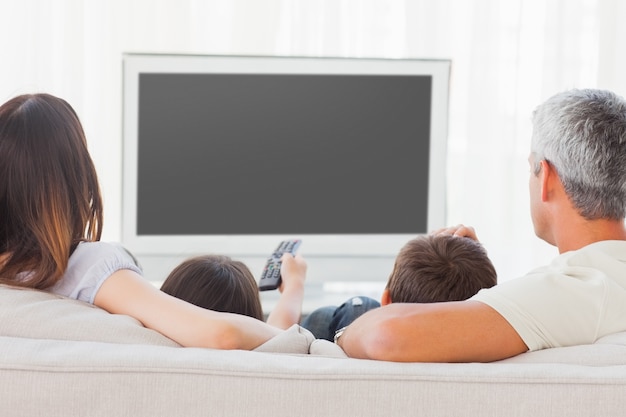 Rodzinny obsiadanie na kanapie ogląda telewizję wpólnie