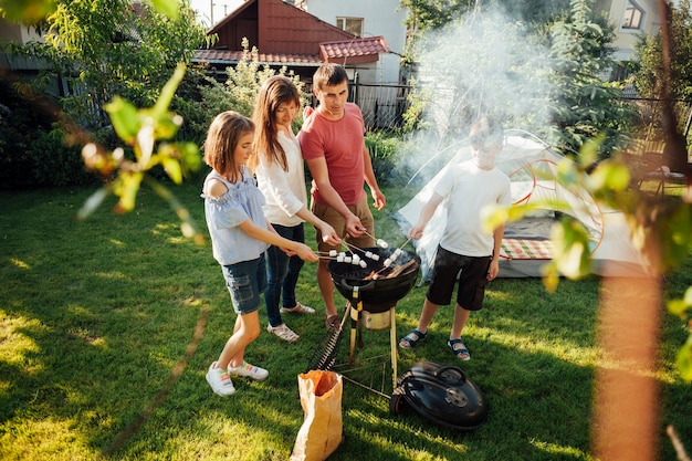 Zdjęcie rodzinny opieczenie marshmallow na grillu przy parkiem