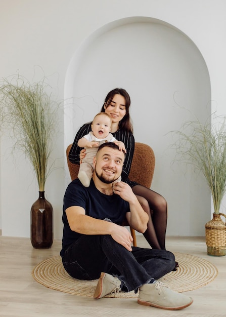 Rodzinny portret szczęśliwej młodej matki i ojca z dzieckiem pozują w domu Wnętrze