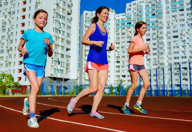 Rodzinny Sport I Sprawność Fizyczna, Szczęśliwa Matka I Dzieciaki Biega Na Stadium Tropimy Outdoors, Dziecko Zdrowego Aktywnego Stylu życia Pojęcie