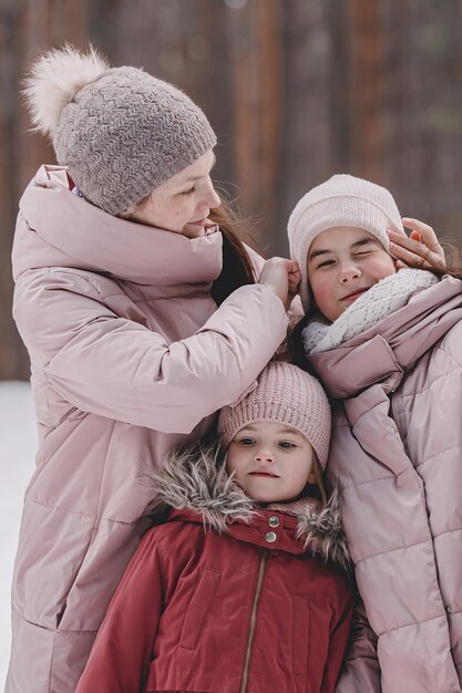 Zdjęcie rodzinny zimowy spacer po lesie matka i córka bawią się zimą w lesie przy słonecznej, mroźnej pogodzie uścisk matki koncepcja świąt bożego narodzenia i nowego roku