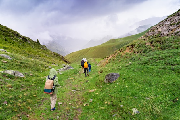 Rodziny z dziećmi wędrujące w wysokich górach we francuskich Alpach w pochmurną letnią pogodę. Koncepcja stylu życia podróży. Wakacje w Vaujany we Francji.