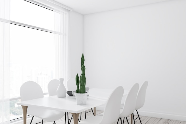 Róg nowoczesnej jadalni z białymi ścianami, drewnianą podłogą, dużym oknem i długim białym stołem z białymi krzesłami.