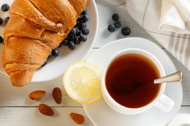 Rogalik z herbatą na białym stole Koncepcja zdrowego stylu życia
