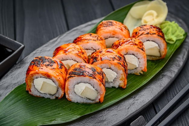 Roladki sushi z grillowanym łososiem i mango Tradycyjne pyszne świeże rolki sushi ustawione na czarnym tle Menu sushi Japońska kuchnia restauracja Azjatyckie jedzenie