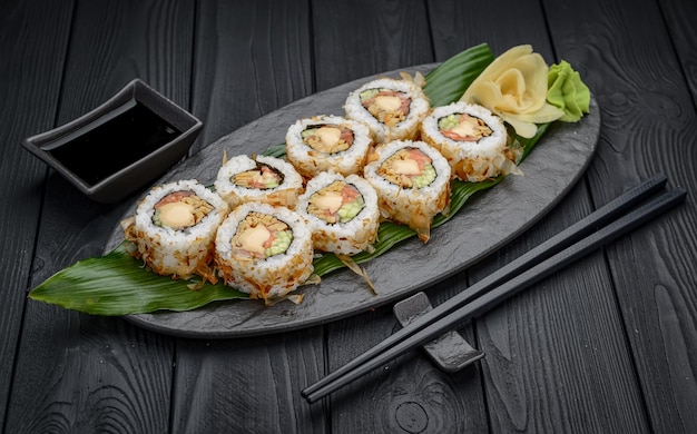 Roladki sushi z serkiem smażonym łososia wiórkami tuńczyka lub suszonym ogórkiem bonito nori Pałeczki trzymające świeżą bułkę katsuobushi w japońskiej restauracji zbliżenie