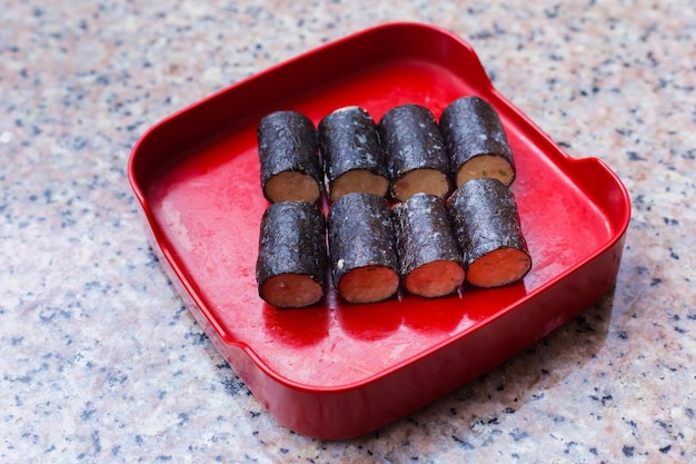 Roladki z wodorostów podano na czerwonym talerzu w restauracji Shabu Sukiyaki