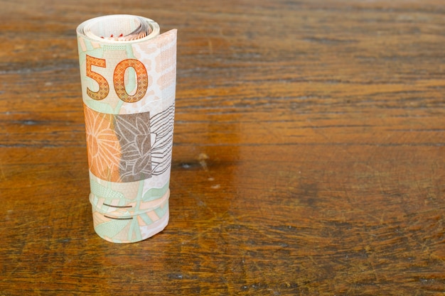 Rolka banknotów brazylijskich pieniędzy na stole