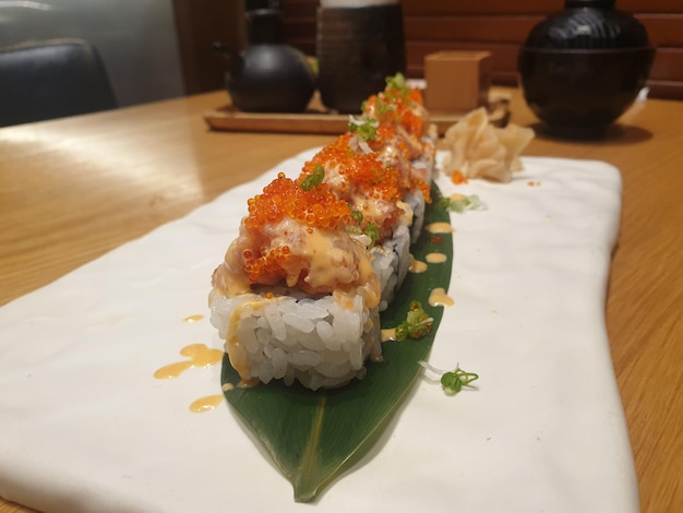 Rolka sushi z łososiem na wierzchu ułożona na białym talerzu Menu sushi Japońskie jedzenie